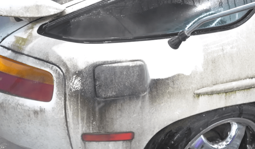a car is being cleaned with a high pressure washer