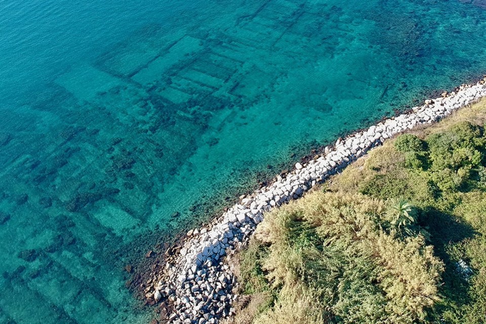 an aerial view of a body of water with a rocky shoreline
