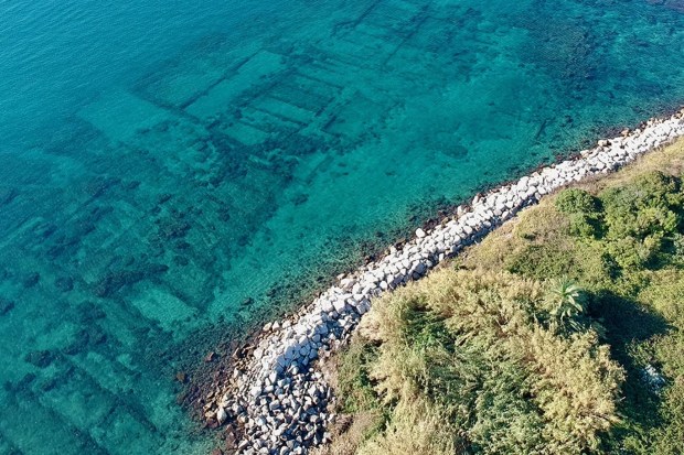 an aerial view of a body of water with a rocky shoreline
