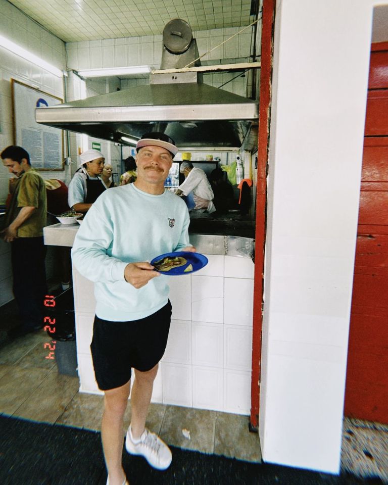 a man holding a plate of food in a kitchen with the date 13 22 14