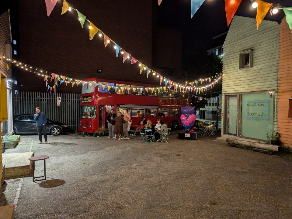 a red double decker bus is parked in a parking lot