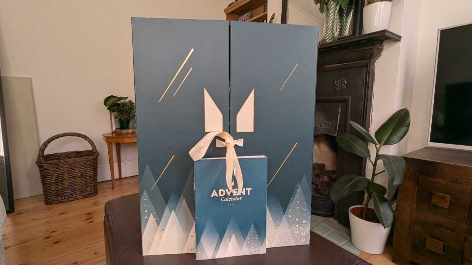 a blue advent calendar sits on a table in front of a fireplace