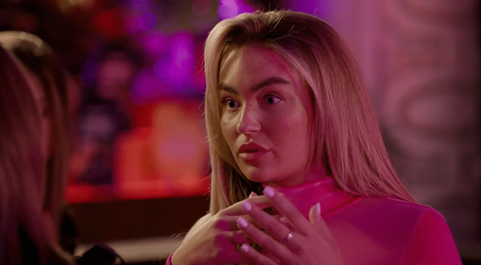a woman in a pink top is talking to another woman