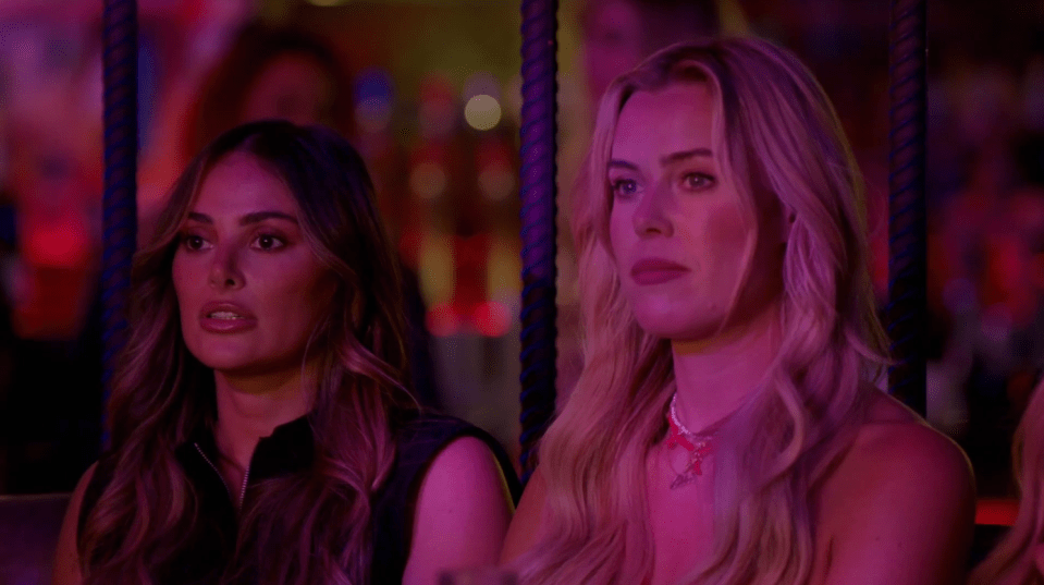 two women sitting next to each other with purple lights behind them