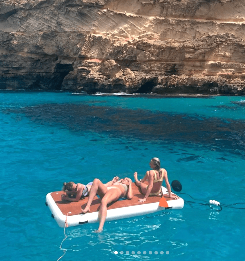three women are laying on a raft in the water