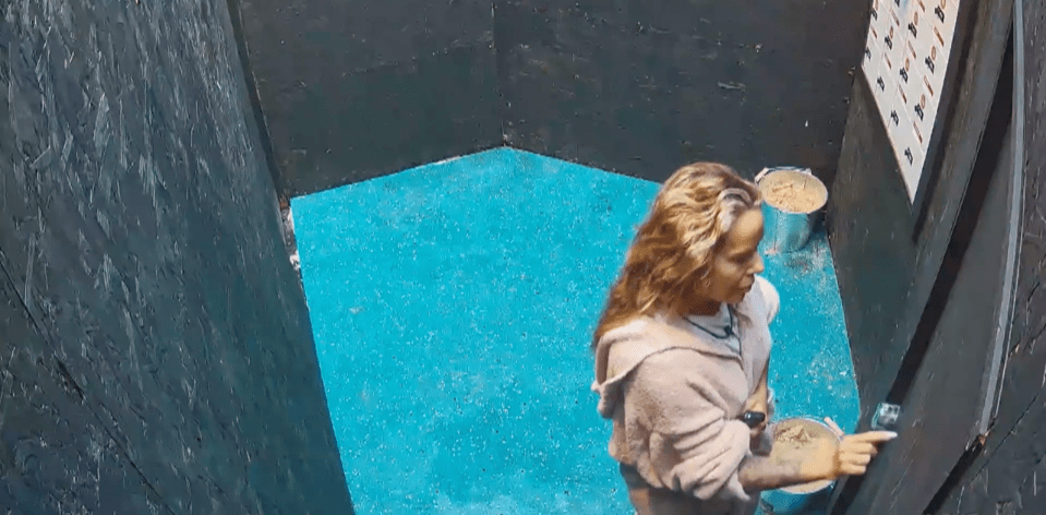 a woman is standing in a dark room with a blue floor