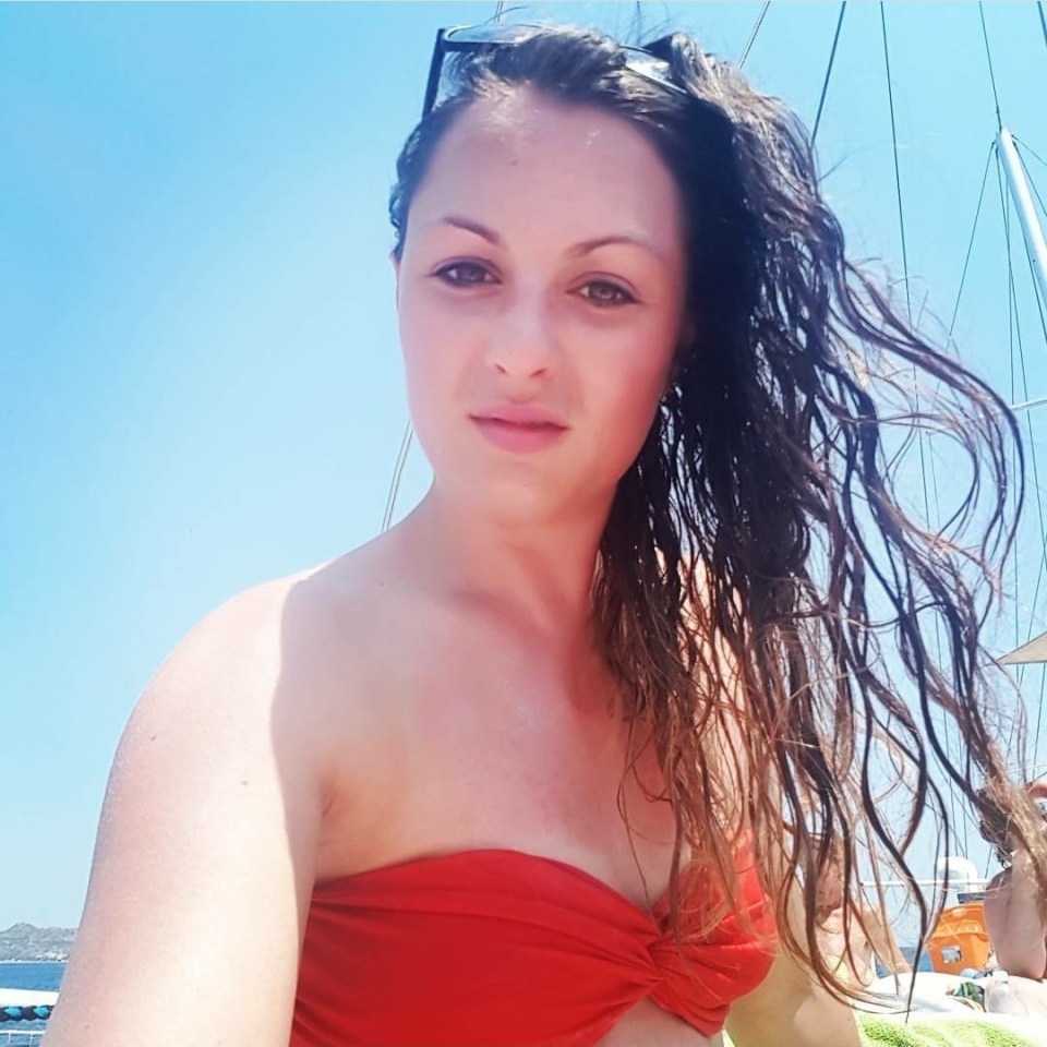 a woman in a red bikini with her hair blowing in the wind