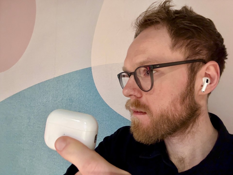 a man wearing glasses and a pair of white airpods