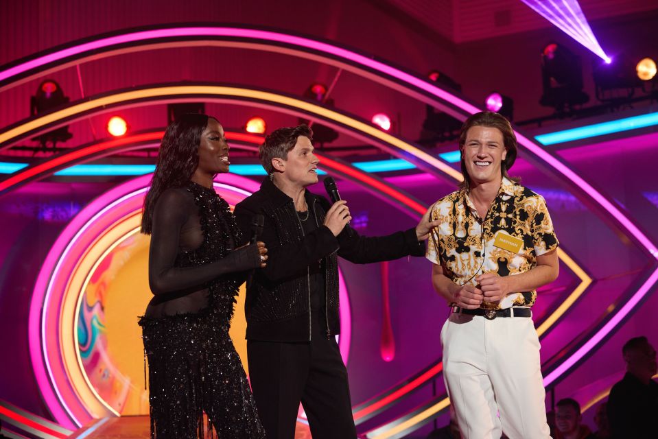three people on a stage with one wearing a shirt that says ' winner ' on it
