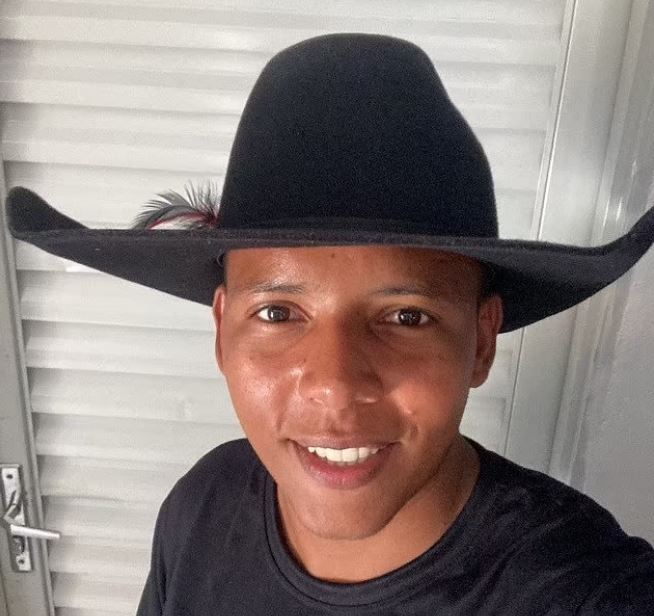 a man wearing a black cowboy hat is smiling for the camera