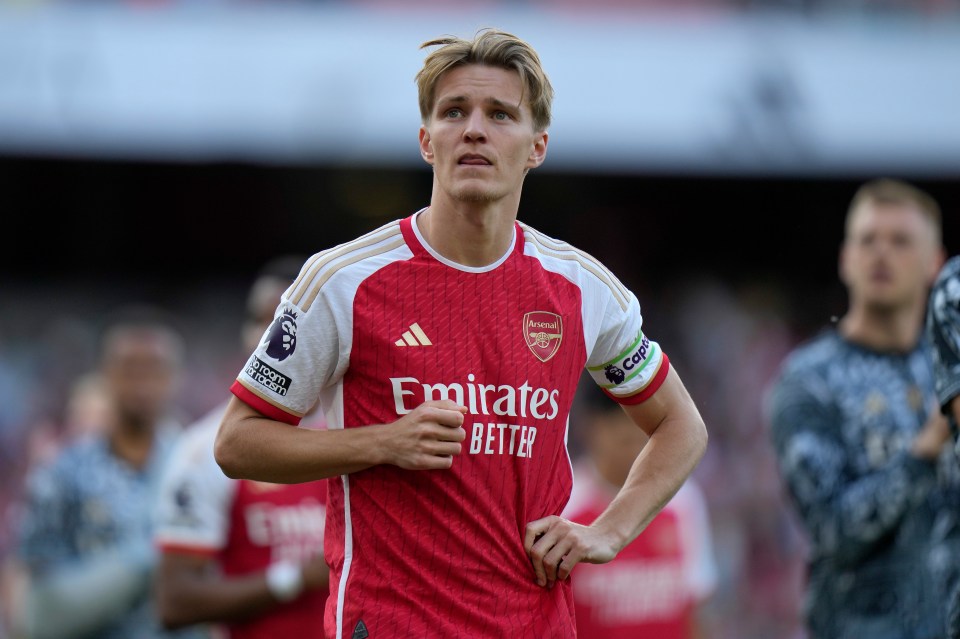 a soccer player wearing a red jersey that says emirates better