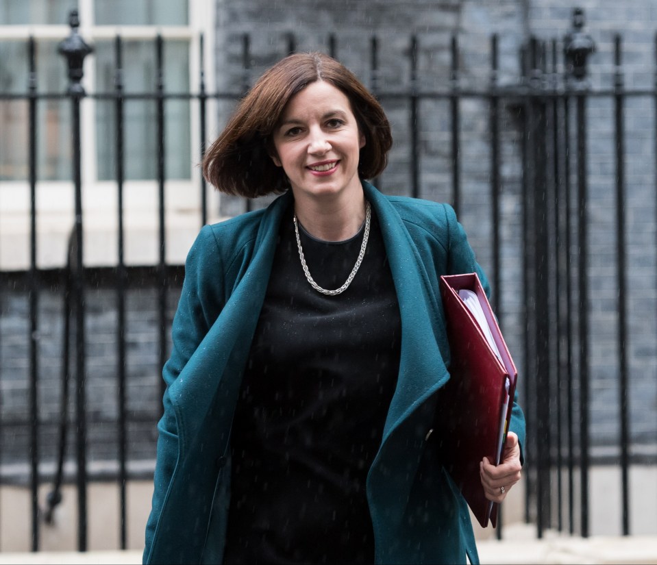 a woman in a blue coat is holding a red folder
