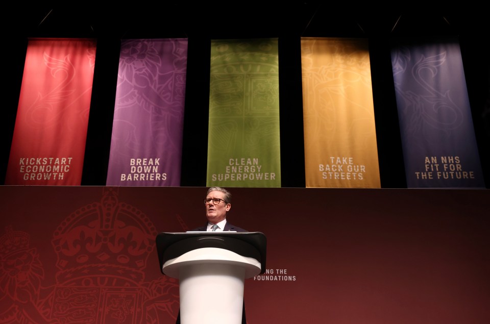 a man stands at a podium in front of banners that say kickstart economic growth clean energy superpower and take back our streets