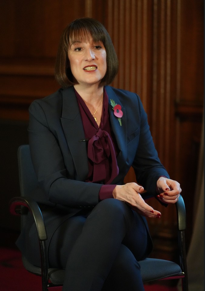 a woman in a suit has a poppy pin on her jacket