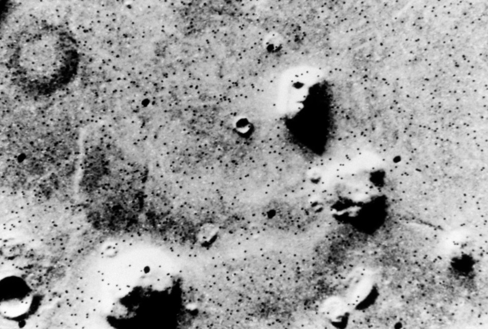 a black and white photo of a surface with small dots on it