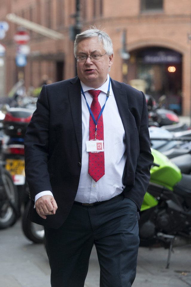 a man in a suit and tie has a lanyard around his neck with a name tag that says ' chris ' on it