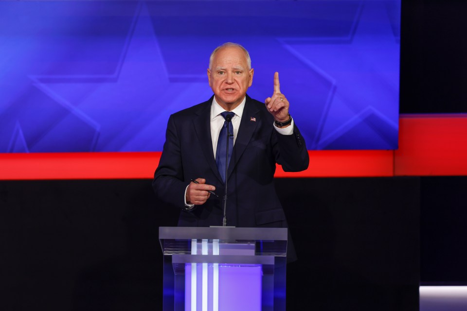 a man in a suit and tie stands at a podium giving a speech