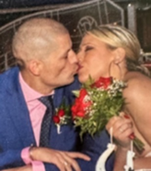a man and woman kissing in front of a sign that says made in heaven