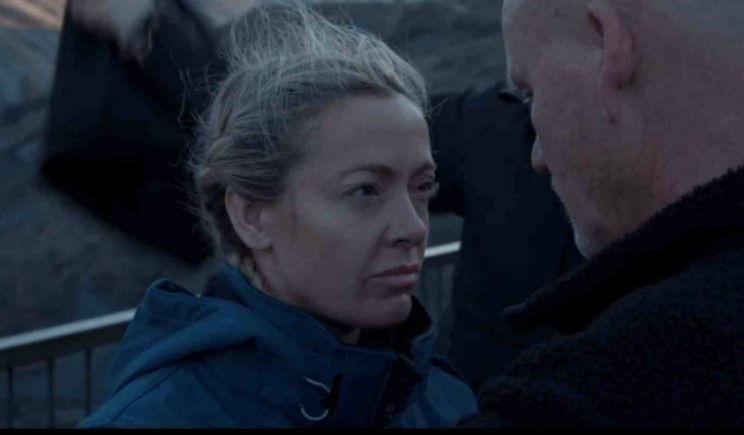 a man and a woman are looking at each other . the woman is wearing a blue jacket .