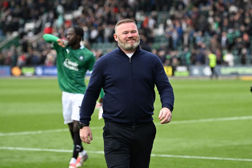 a man with a beard is walking on a soccer field