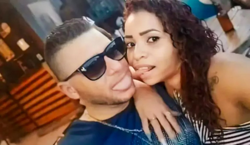 a man and a woman are posing for a picture together . the woman is wearing sunglasses .