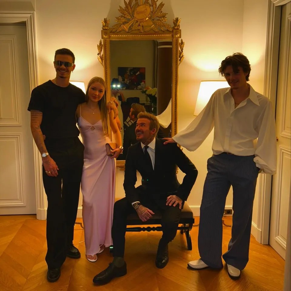 a group of people posing for a picture in front of a mirror