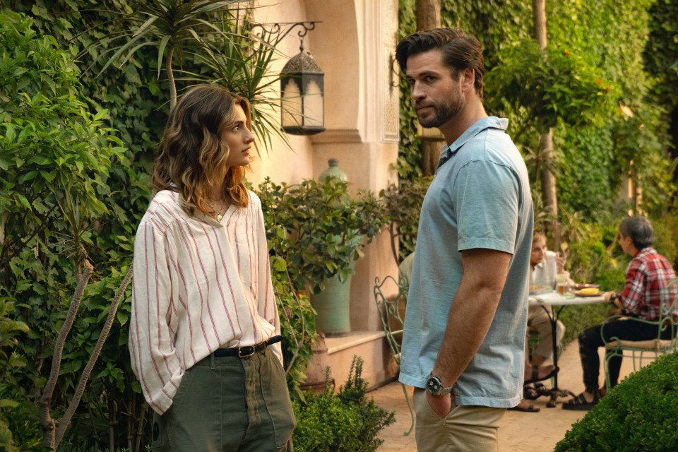 a man and a woman are standing next to each other in a garden