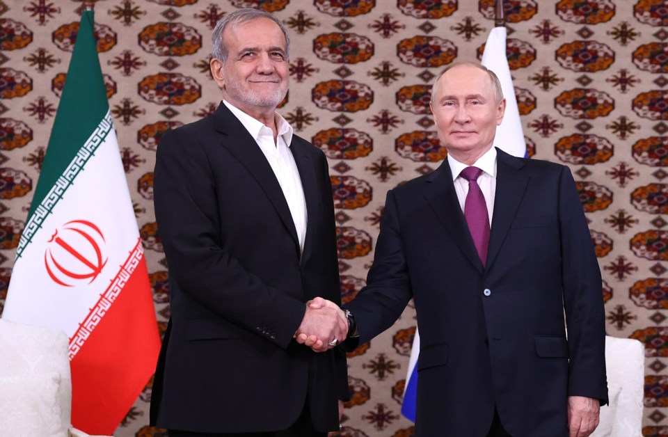 a man in a suit and tie shakes hands with another man