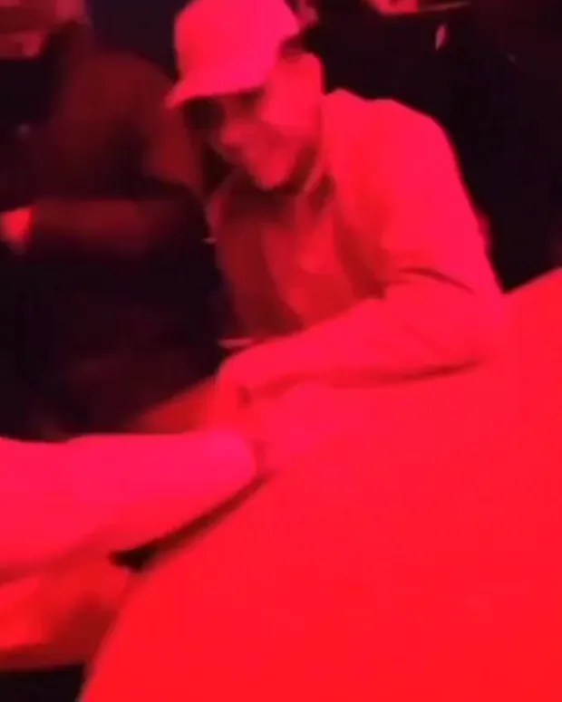 a man in a hat is sitting at a table in a red room .