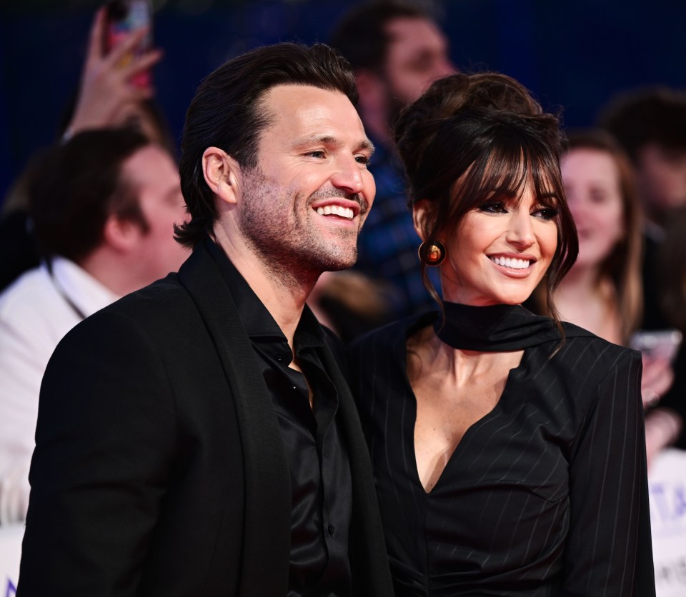 a man and woman are posing for a picture on a red carpet