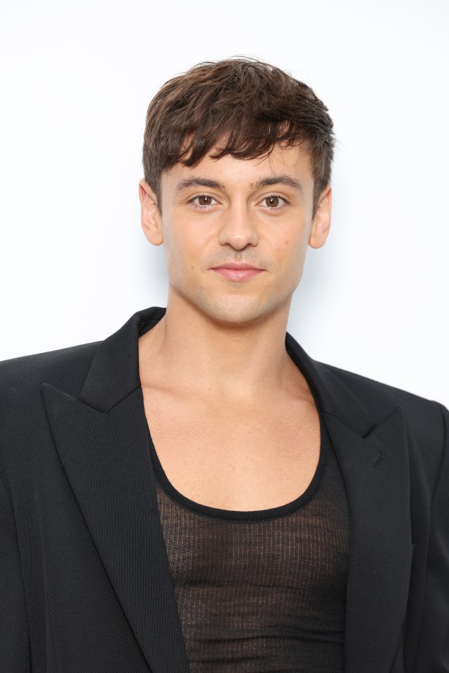a young man wearing a black jacket and a black tank top