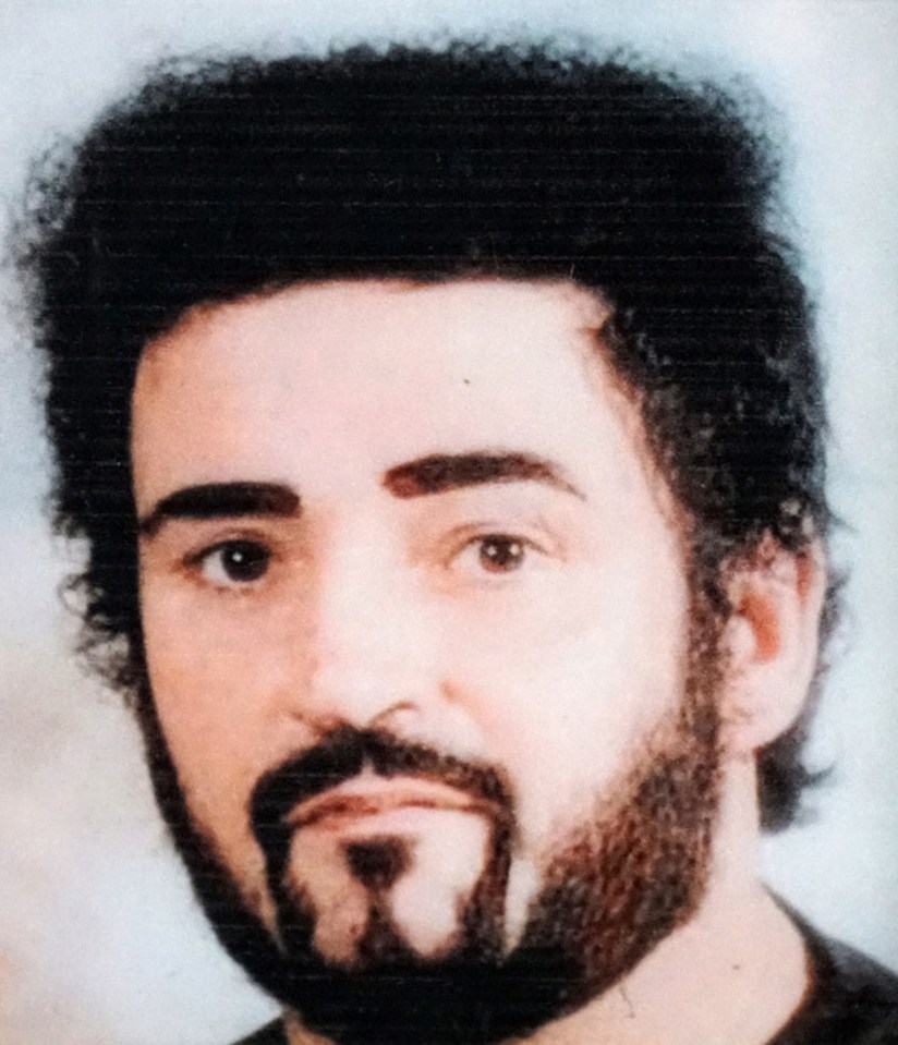 a man with a beard and curly hair looks at the camera