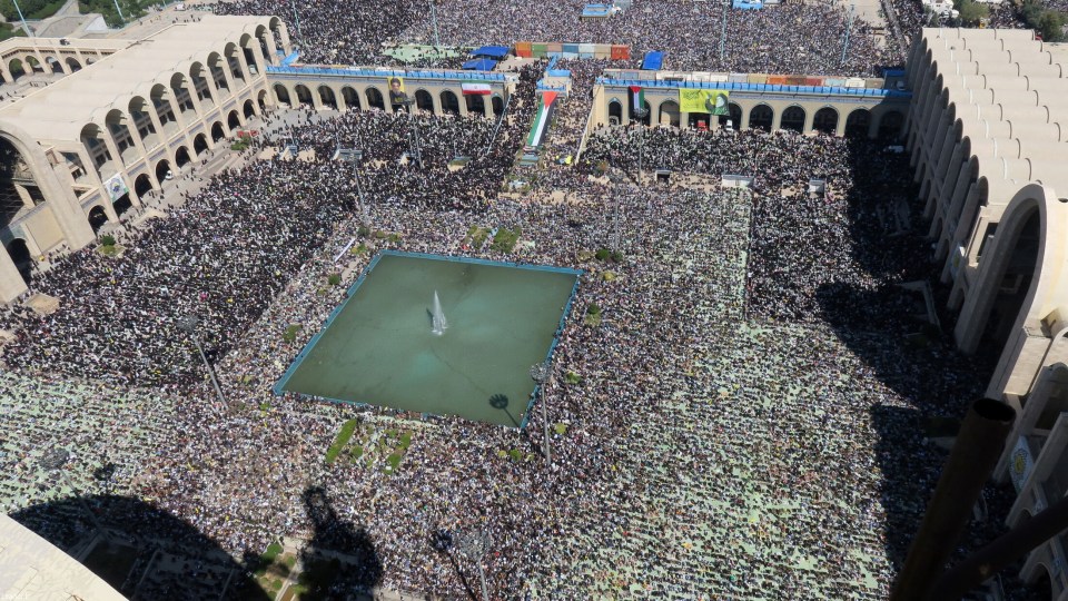 a large crowd of people are gathered around a fountain