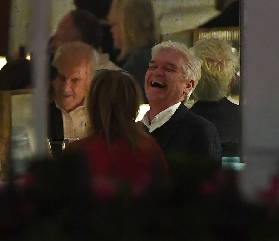 a man is laughing in a crowd of people