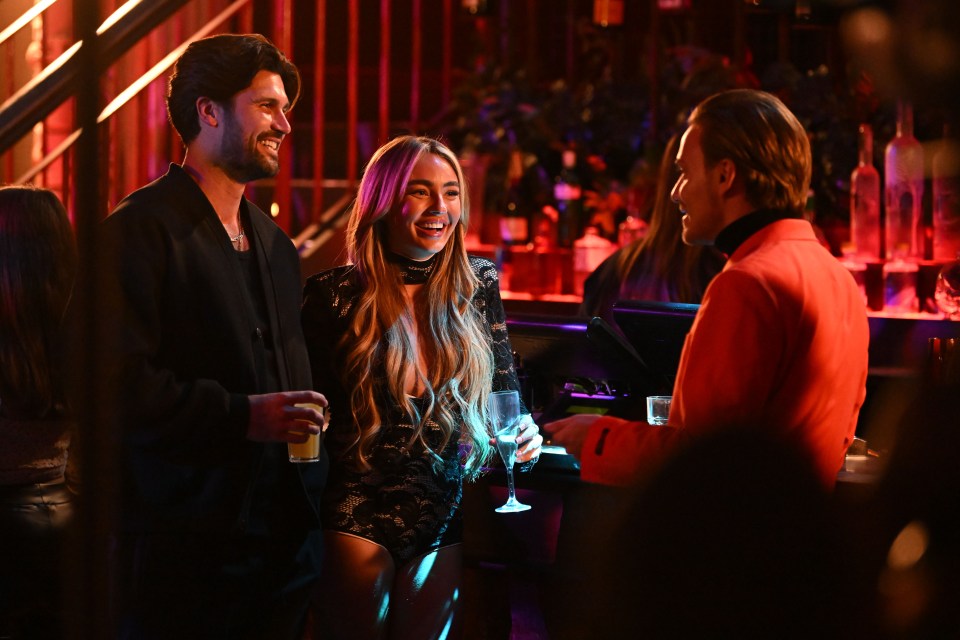 a man in a red suit is talking to a woman in a black dress