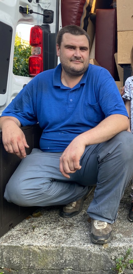 a man in a blue shirt is standing in front of a door