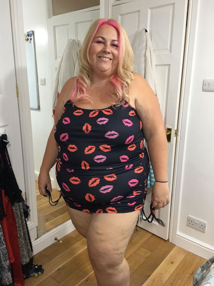 a woman with pink hair is wearing a swimsuit with pink lips on it