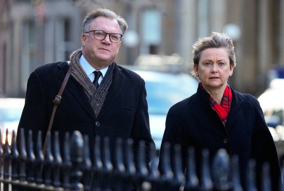 a man and a woman are walking down a street with a caption that says ' alexander smith ' on it