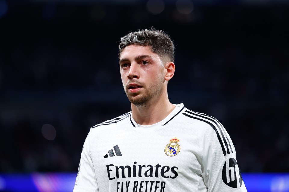 a soccer player wearing a white emirates fly better jersey