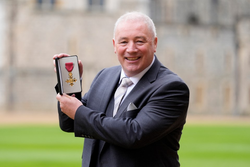 a man in a suit and tie is holding a medal