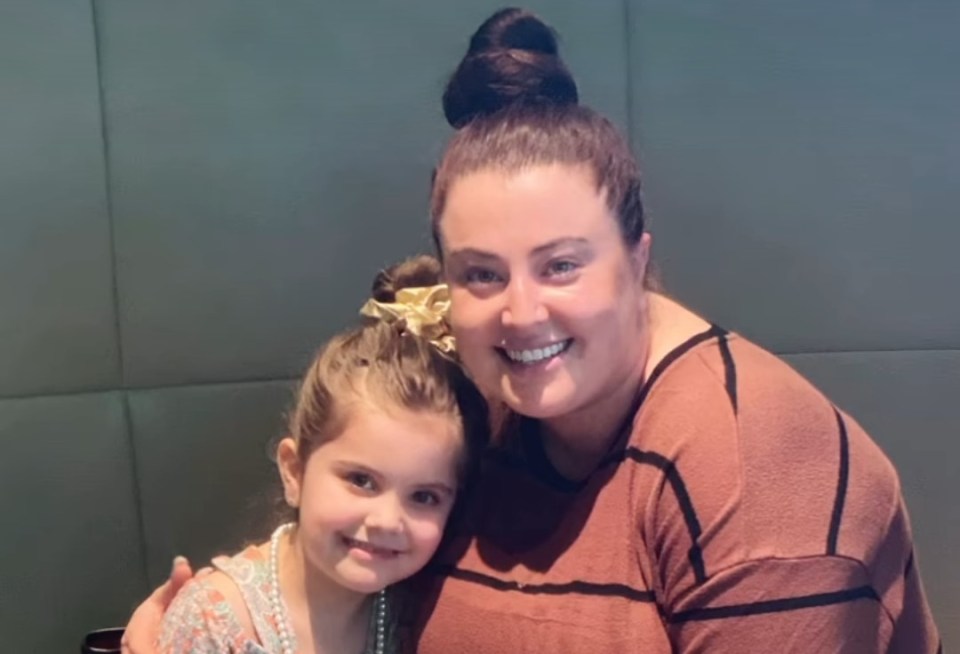 a woman and a little girl are posing for a picture
