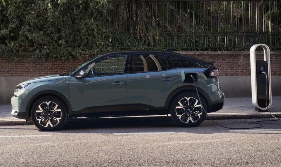 a green car is plugged into a charging station