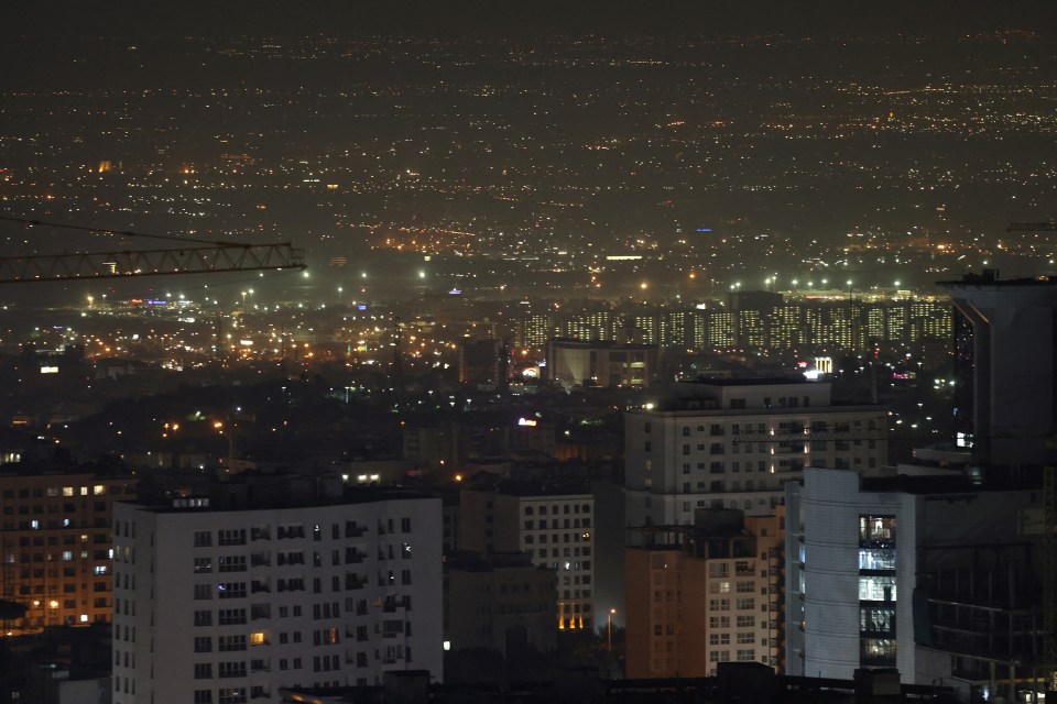 an aerial view of a city at night with buildings lit up