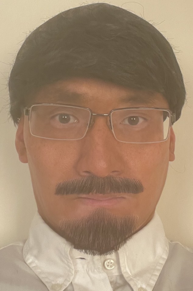 a man with glasses and a beard looks at the camera