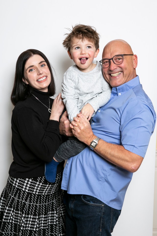 a man wearing glasses and a watch holds a little boy in his arms