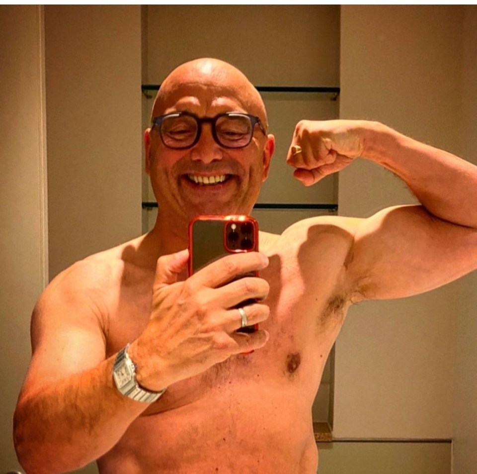 a shirtless man is taking a selfie with his phone