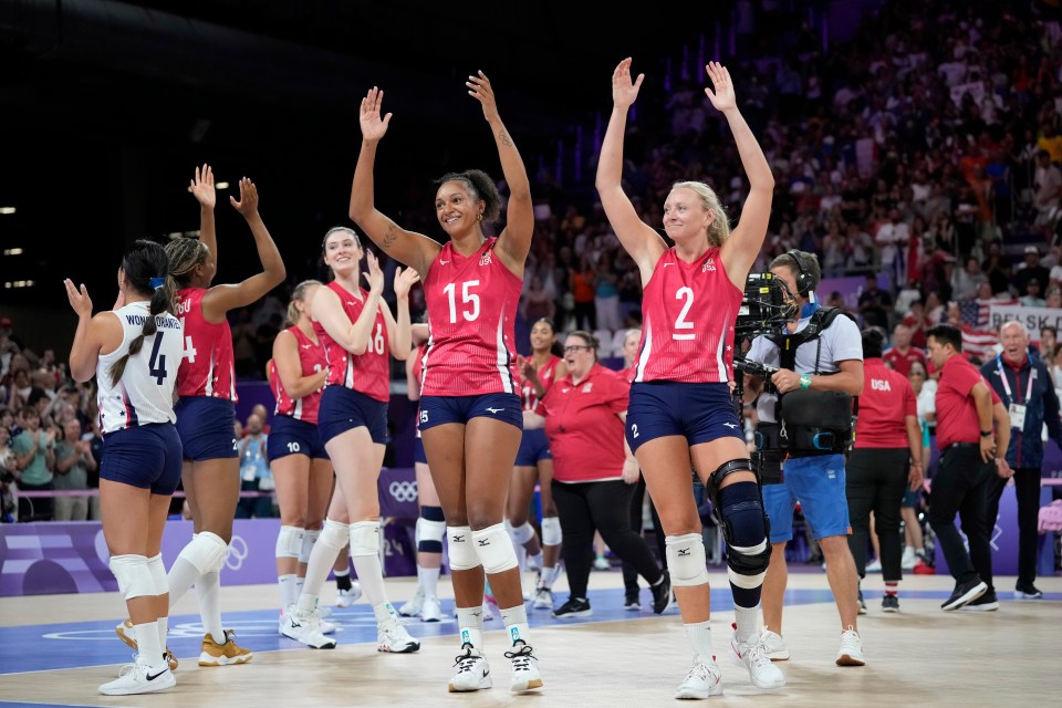 a group of volleyball players with one wearing number 15