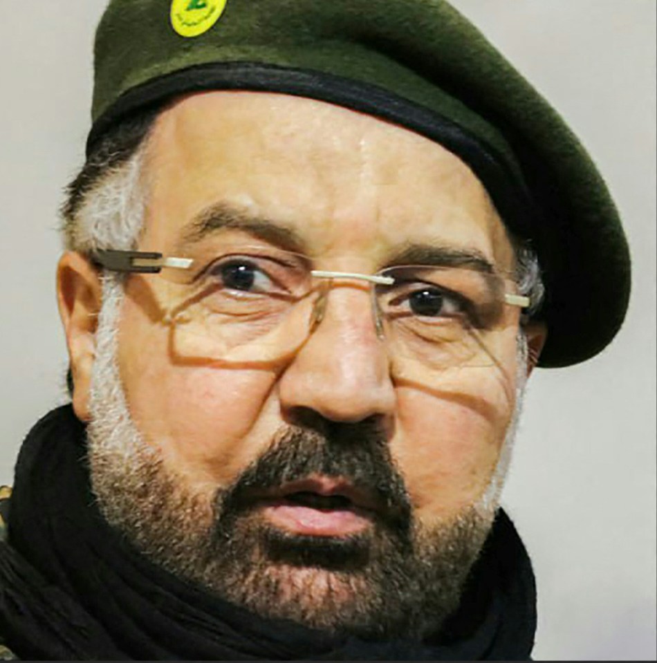 a man with glasses and a beard wears a green beret