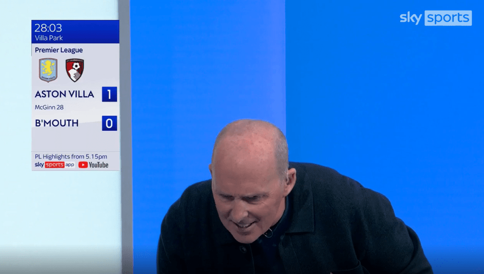 a man stands in front of a screen that says sky sports