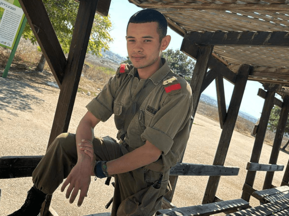 a man in a military uniform is sitting on a bench